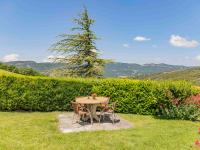 a table and chairs in a yard with a tree at Holiday Home Le Cèdre - RSB100 by Interhome in Roche-Saint-Secret