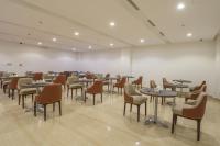 a restaurant with tables and chairs in a room at Erfad Hotel - Riyadh in Riyadh
