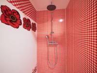 a red tiled shower with red flowers on the wall at Yourtissimo in Laprugne