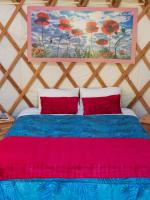 a bedroom with a bed with a painting on the wall at Yourtissimo in Laprugne