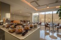 a buffet line with food on it in a restaurant at Erfad Hotel - Riyadh in Riyadh