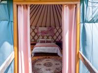 a bedroom with a bed in a tent at Yourtissimo in Laprugne