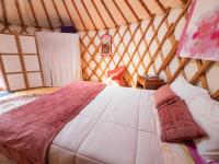 a bedroom with a bed in a yurt at Yourtissimo in Laprugne