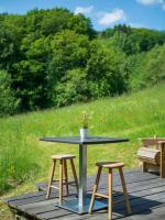 a table with two stools and a plant on it at Yourtissimo in Laprugne