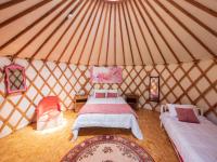 a bedroom with two beds in a yurt at Yourtissimo in Laprugne