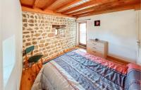 a bedroom with a bed and a brick wall at Amazing Home In Essertines-en-chtelne With 3 Bedrooms in Essertines-en-Châtelneuf