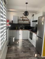 a kitchen with white cabinets and a stainless steel refrigerator at Chambre 2 personnes 24h du Mans in Le Mans