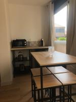 a kitchen with two wooden tables and a microwave at Sublime Sanary plage in Sanary-sur-Mer