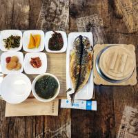 einen Tisch mit einem Teller mit Lebensmitteln und Schüsseln in der Unterkunft Jeju M Resort in Seogwipo