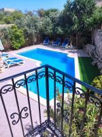 a swimming pool next to a balcony with chairs at Ta’ Peppi Farmhouse in Qala