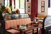 uma sala de jantar com mesa e cadeiras, pratos e utensílios em The Hoxton, Berlin em Berlim