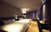 a hotel room with two beds and a television at Chiayi Guanzhi Hotel in Chiayi City