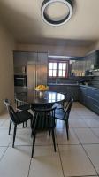 a kitchen with a table and chairs with a bowl of fruit on it at Villa Khaki 