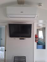 einen Flachbild-TV an der Wand in einem Wohnwagen in der Unterkunft Mobil Home (Clim, Tv)- Camping Narbonne-Plage 4* - 020 in Narbonne-Plage