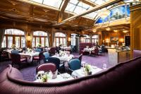 a dining room with tables and chairs and ceilings at Grand Hotel Zermatterhof in Zermatt