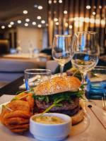 un plato con una hamburguesa y papas fritas y copas de vino en Golden Tulip Dieppe Hôtel & Spa, en Saint-Aubin-sur-Scie