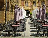 Charleville-Mézières: belle vue Place Ducale في شارلفيل-ميزيير: صف من الطاولات والكراسي مع المظلات