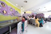 eine Gruppe von Personen, die in einem Restaurant sitzen in der Unterkunft Hotel Samrat International in Mount Ābu