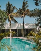 a swimming pool in front of a house with palm trees at Ayom Suite in Mataram