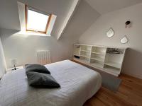 a bedroom with a large white bed and a window at Le ker Maclow in Saint Malo