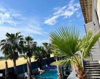 a view of a resort with palm trees and a swimming pool at Mas La Farelle Chambre d&#39;hote,Fitness &amp; Salle de jeux Gratuite &amp; SPA en supplément in Nîmes