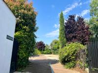 a gate to a garden with bushes and trees at Mas La Farelle Chambre d&#39;hote,Fitness &amp; Salle de jeux Gratuite &amp; SPA en supplément in Nîmes