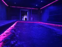 an indoor pool with red and purple lights in a room at Mas La Farelle Chambre d&#39;hote,Fitness &amp; Salle de jeux Gratuite &amp; SPA en supplément in Nîmes