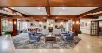 una gran sala de estar con sillas azules y una mesa. en Ayres Suites Mission Viejo - Lake Forest, en Mission Viejo