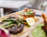 een bord met eten met vlees en groenten op een tafel bij Ahau Tulum - Beachfront Hotel in Tulum