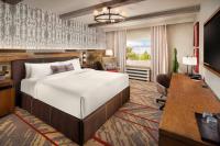 ein Schlafzimmer mit einem Bett, einem Schreibtisch und einem Fernseher in der Unterkunft Silverton Casino Lodge in Las Vegas
