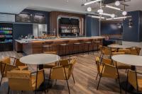 Courtyard by Marriott Olympia في أولمبيا: مطعم به طاولات وكراسي وبار