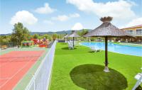 a swimming pool with a tennis court and an umbrella at Amazing Home In Grospierres With Outdoor Swimming Pool, Wifi And 2 Bedrooms in Grospierres