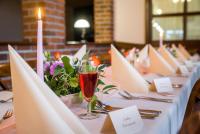 a long table with white table cloth and a glass of wine at Hotel Bílý Beránek Kralovice in Kralowitz
