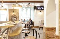 two people sitting at a bar in a restaurant at SUITE DEL CASTILLO in Andújar