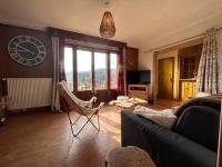 a living room with a couch and a clock on the wall at Le Repère des Quatre Dubois in Le Tholy