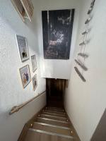 a hallway with a staircase with a painting on the wall at Le Repère des Quatre Dubois in Le Tholy