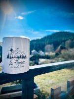 a coffee cup sitting on a rail with a view at Le Repère des Quatre Dubois in Le Tholy
