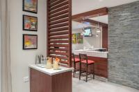 a kitchen with a counter and a bar with chairs at Hotel Savoy and Conference Centre in Mthatha