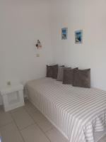 a white bedroom with a bed and a table at Theofanis Studios in Agia Anna Naxos