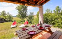 a wooden table with red plates and wine glasses at Amazing Home In Grospierres With Outdoor Swimming Pool, Wifi And 2 Bedrooms in Grospierres