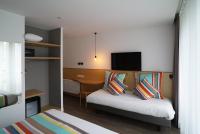 a bedroom with a bed with pillows and a desk at La Regence in Courbevoie