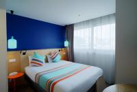 a bedroom with a large bed with a blue wall at La Regence in Courbevoie