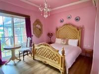 a bedroom with pink walls and a bed with a chandelier at England Castle B&amp;B in Wujie