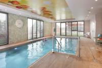 a large indoor swimming pool with a clock on the wall at DOMITYS LES CERNEAUX in Hazebrouck