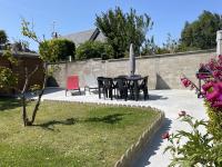 a patio with a table and chairs in a yard at La Renaissance in Bayeux