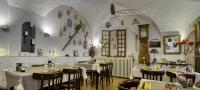 a restaurant with tables and chairs and a clock on the wall at Hotel Pascal in Allos