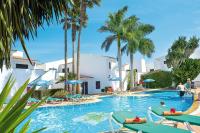 una piscina con tumbonas y palmeras en Puerto Caleta, en Caleta de Fuste