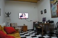 a living room with a couch and a table with a tv at Pensión San Benito Abad in Seville