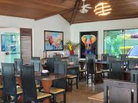 una sala da pranzo con tavoli e sedie e un elefante sul muro di Pousada Costa Del Sol a Búzios