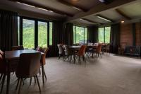 a dining room with tables and chairs and windows at Panorama Ushba in Mestia